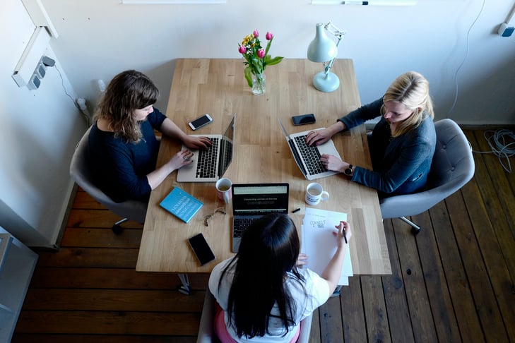 Three women working on their laptops at the desk