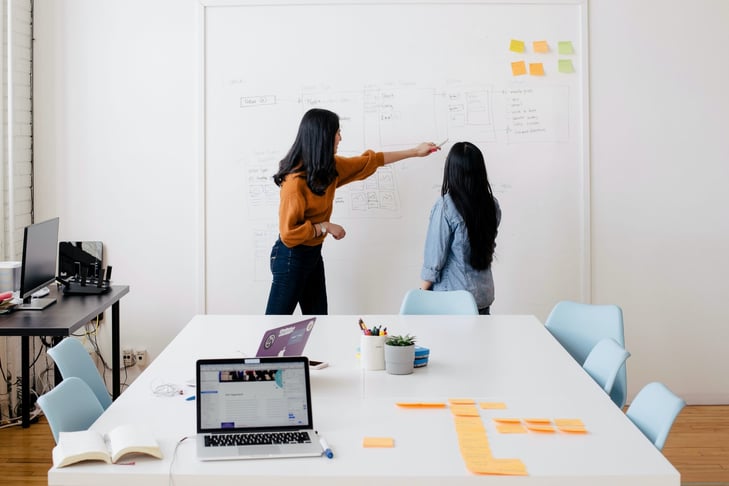 Two female coworkers at the board