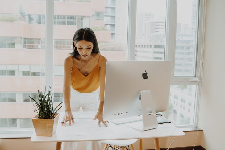 A woman standing at her desk