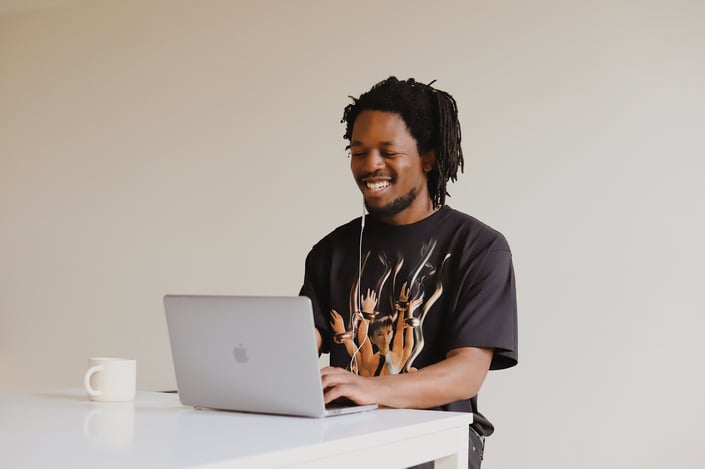 Smling man of color on his computer