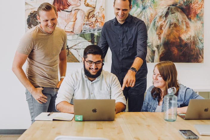 A group of four in front of laptop