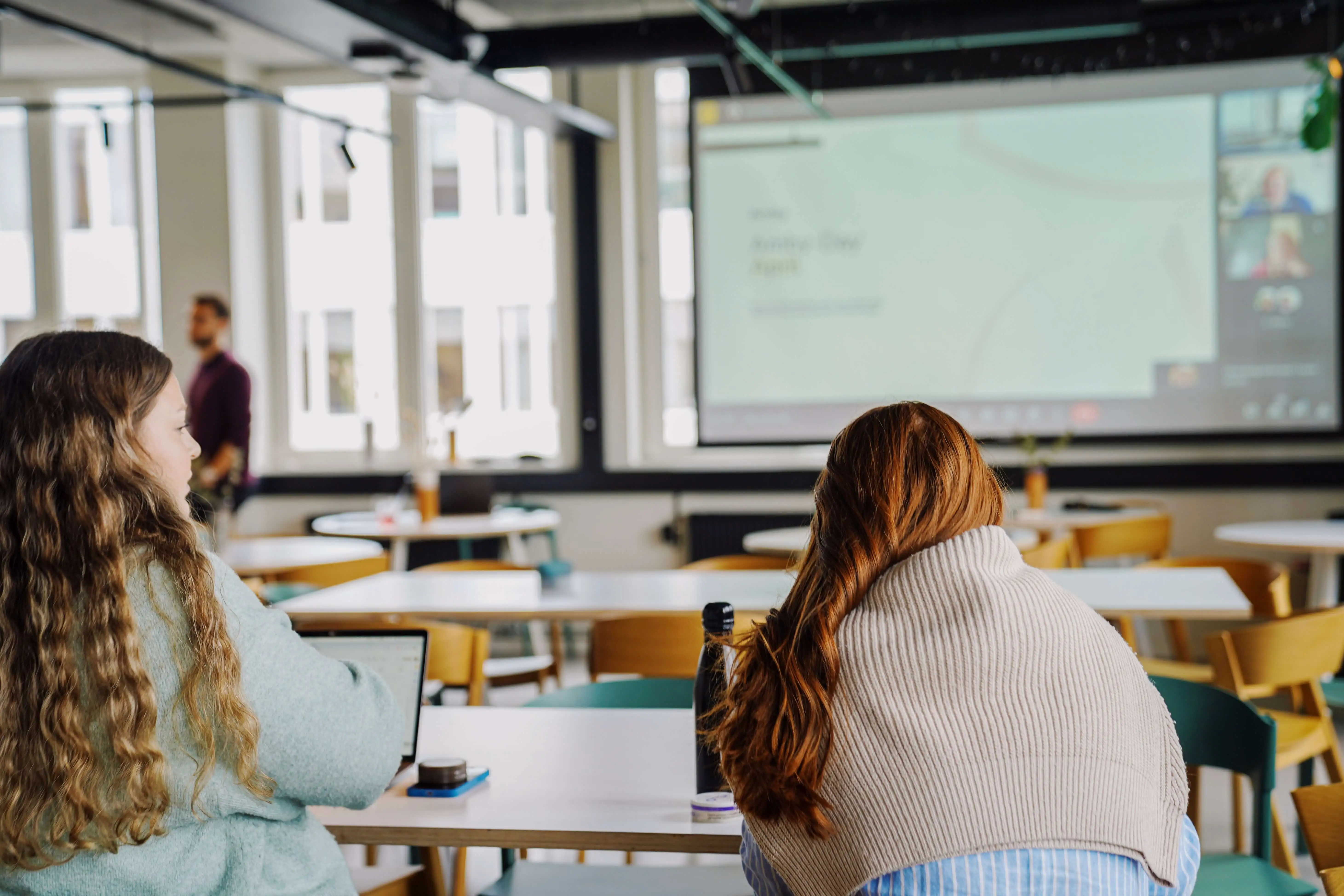 Two people watching a presentation