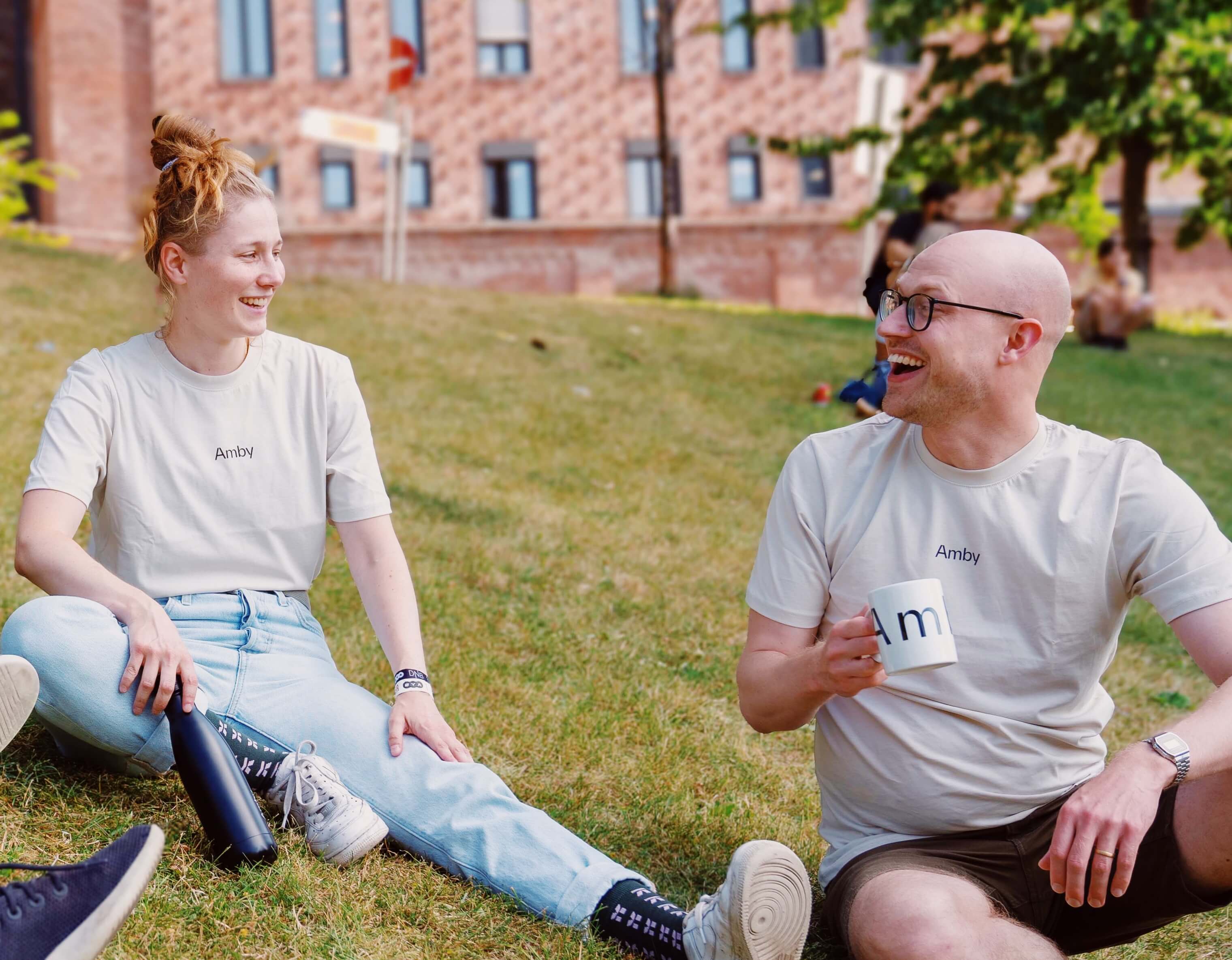 Two people sitting on a grass hill