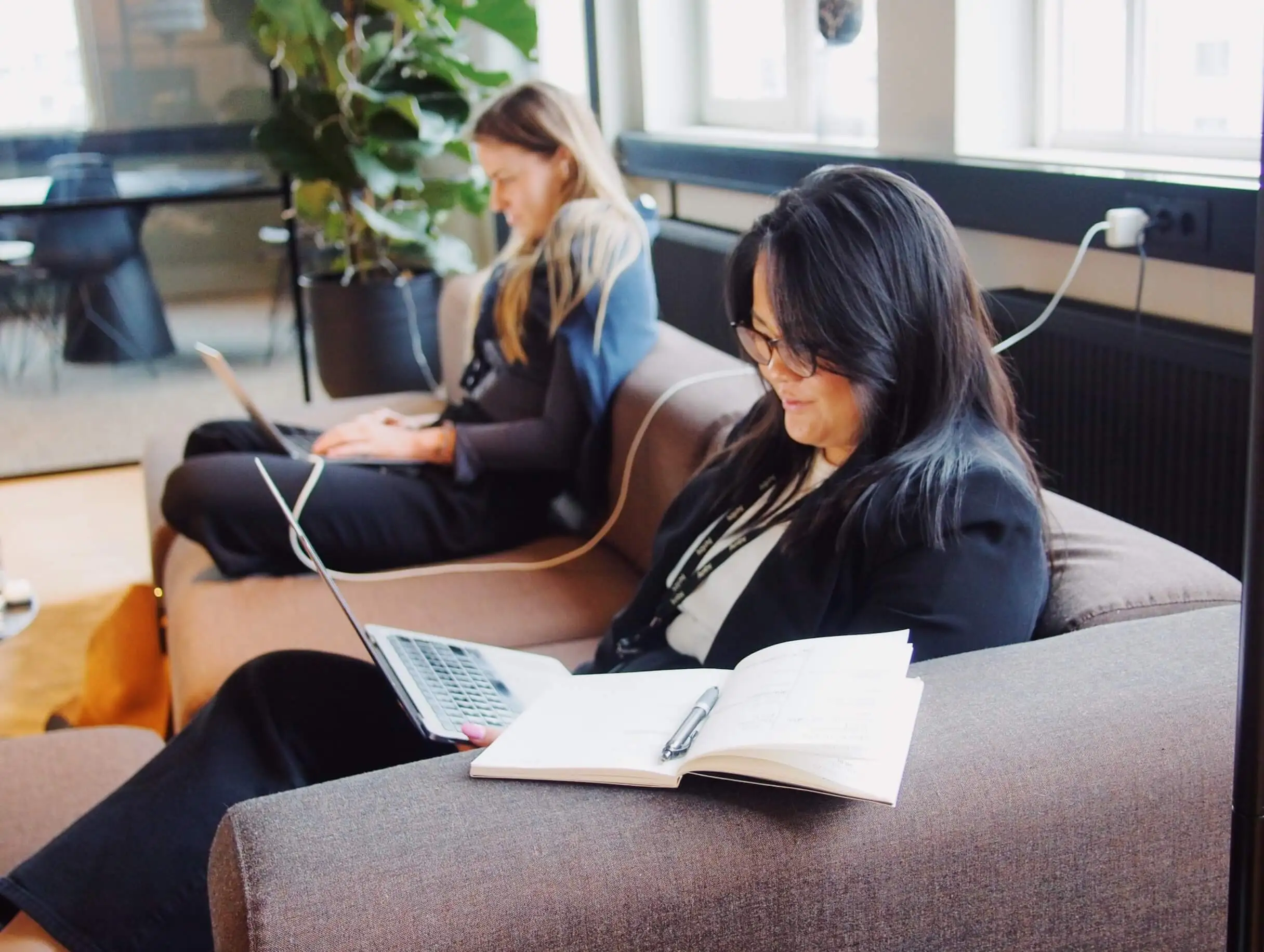 two women working on couch